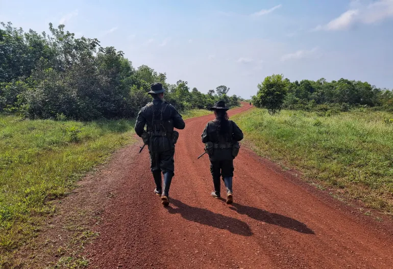 Guerrillas from the EMC walk down a dirt road in Colombia