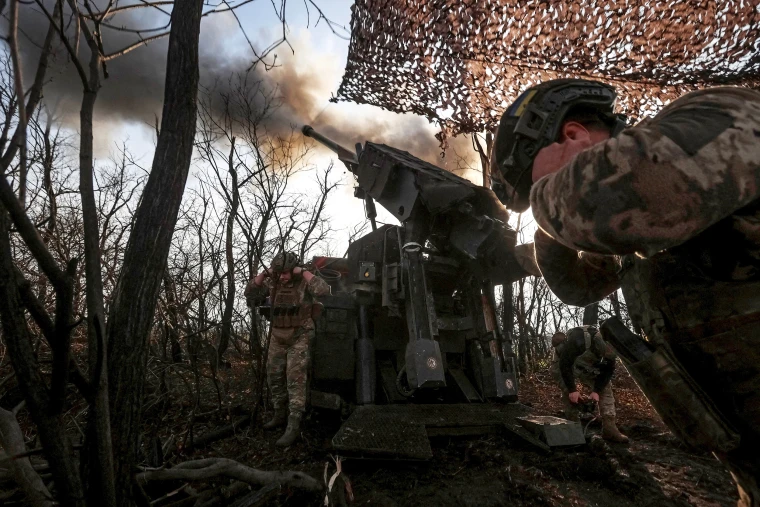 Ukrainian servicemen fire a self-propelled howitzer towards Russian troopsn near the front line town of Pokrovsk
