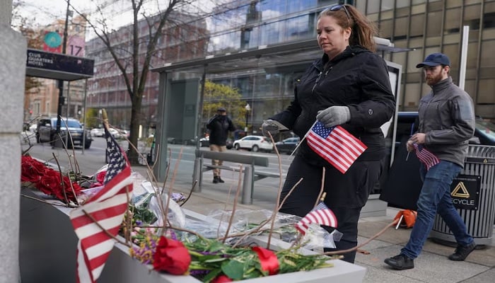DC residents bring flags for a memorial set up near the White House after two National Guard members were shot in Washington, DC, US, November 28, 2025.— Reuter