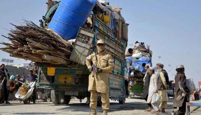 A Taliban security personnel stands guard as deported Afghan refugees from Pakistan arrive at the zero-point border crossing between Afghanistan and Pakistan, in the Spin Boldak district of Kandahar province on October 27, 2025. — AFP