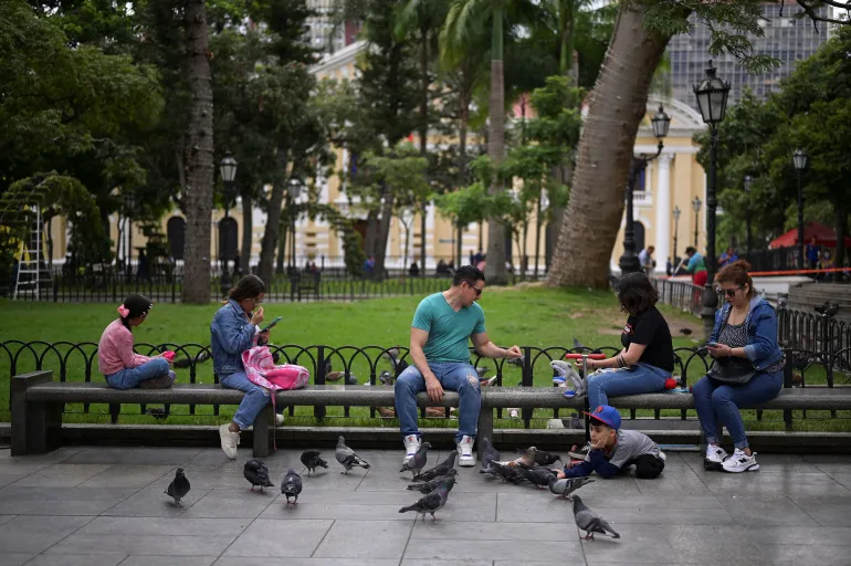 People rest on a bench in a public square, amid rising tensions between the government of Venezuela's President Nicolas Maduro