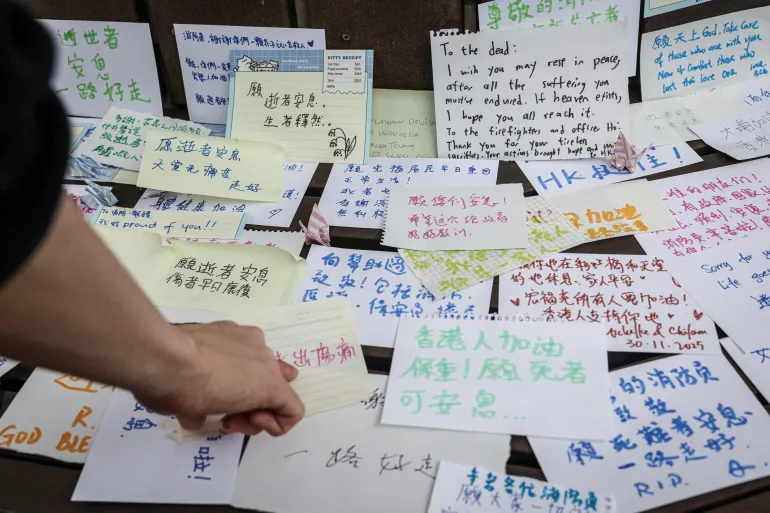 People leave notes with well-wishes for those affected by the deadly fire at the Wang Fuk Court housing complex, in Tai Po, Hong Kong, China, November 30, 2025. REUTERS/Tyrone Siu SEARCH "HONG KONG FIRE PICTURE" FOR THIS STORY. SEARCH "WIDER IMAGE" FOR ALL STORIES.