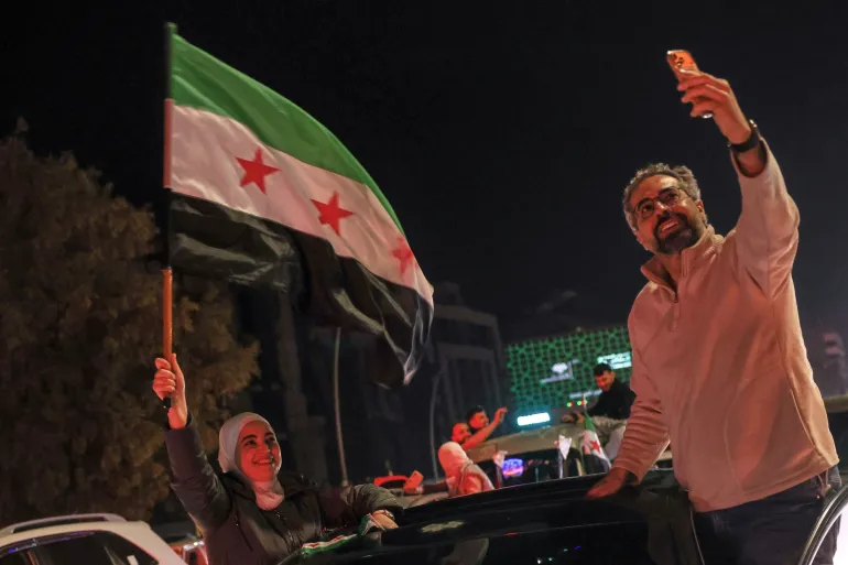 Syrians celebrate the first anniversary of the ousting of the Bashar Assad regime in Damascus, Syria, early Saturday, Dec. 6, 2025. (AP Photo/Ghaith Alsayed)
