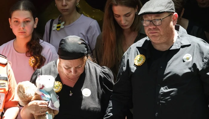 Valentyna (L), mother of 10-year-old Matilda, who was killed in the December 14 Bondi Beach shooting attack, and Matilda´s father (R) leave behind their daughter´s coffin after the funeral service in Sydney on December 18, 2025. — AFP