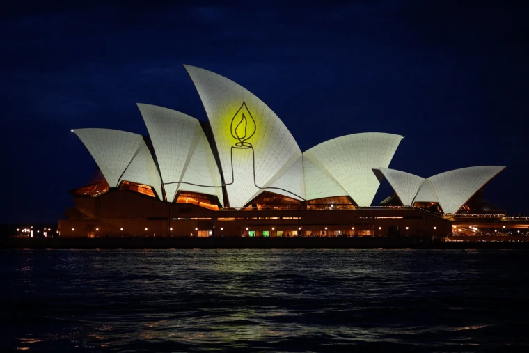 The Sydney Opera House is illuminated with candlelights on Sunday, as part of a national day of reflection honoring the victims of the Bondi Beach terrorist attack.