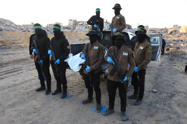 Islamic Jihad and Hamas militants transport a white body bag believed to carry the remains of an Israeli hostage in the town of Beit Lahia in the northern Gaza Strip on December 3, 2025.