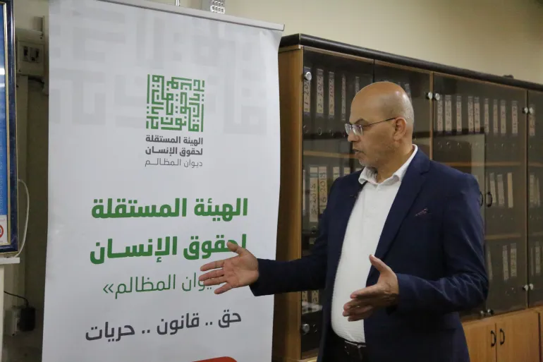 Farid al-Atrash stands in front of a banner