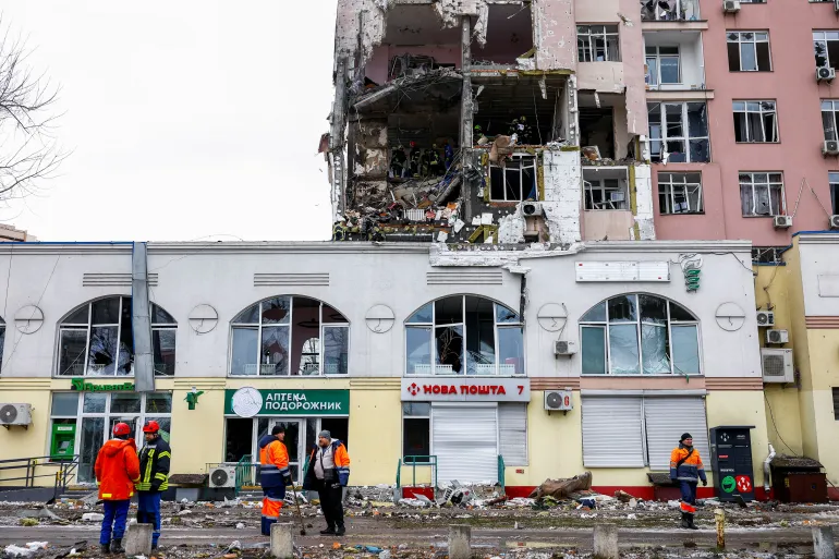 Municipal employees and firefighters work at the site of an apartment building hit during Russian missile and drone strikes, amid Russia’s attack on Ukraine in Kyiv, Ukraine December 27, 2025. REUTERS/Valentyn Ogirenko