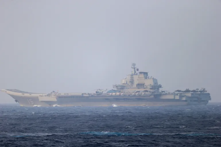 FILE PHOTO: Chinese aircraft carrier Liaoning sails through the Miyako Strait near Okinawa on its way to the Pacific in this handout photo taken by Japan Self- Defence Forces and released by the Joint Staff Office of the Defence Ministry of Japan on April 4, 2021. Joint Staff Office of the Defence Ministry of Japan/HANDOUT via REUTERS ATTENTION EDITORS - THIS IMAGE WAS PROVIDED BY A THIRD PARTY. MANDATORY CREDIT. THIS PICTURE WAS PROCESSED BY REUTERS TO ENHANCE QUALITY. AN UNPROCESSED VERSION HAS BEEN PROVIDED SEPARATELY/File Photo