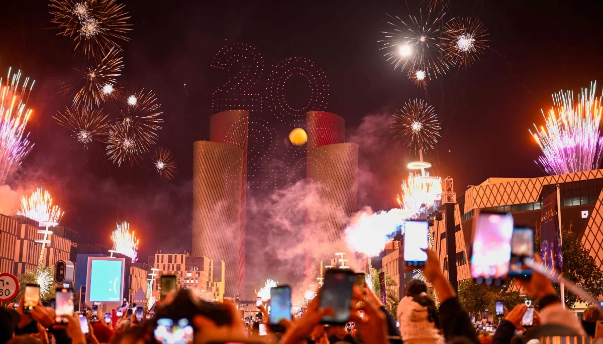 People watch fireworks light up the sky during New Year celebrations in Lusail early on January 1, 2026. — AFP