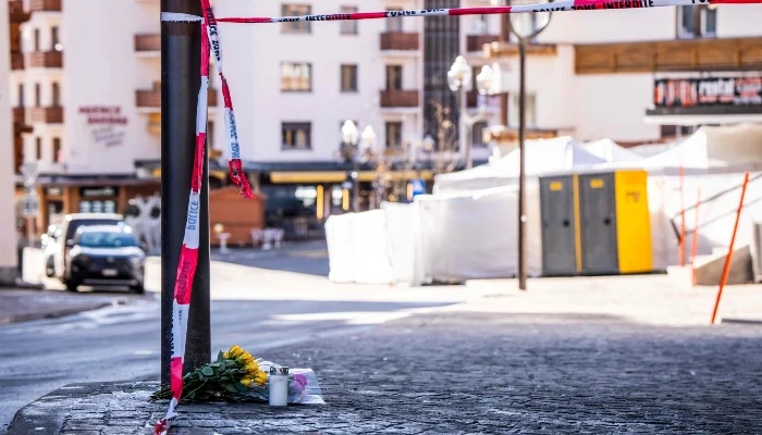 A photograph taken on January 1, 2026, shows flowers and candles laid on the ground near the bar Le Constellation following an explosion that ripped through the venue in Crans-Montana, during New Years Eve celebrations. — AFP