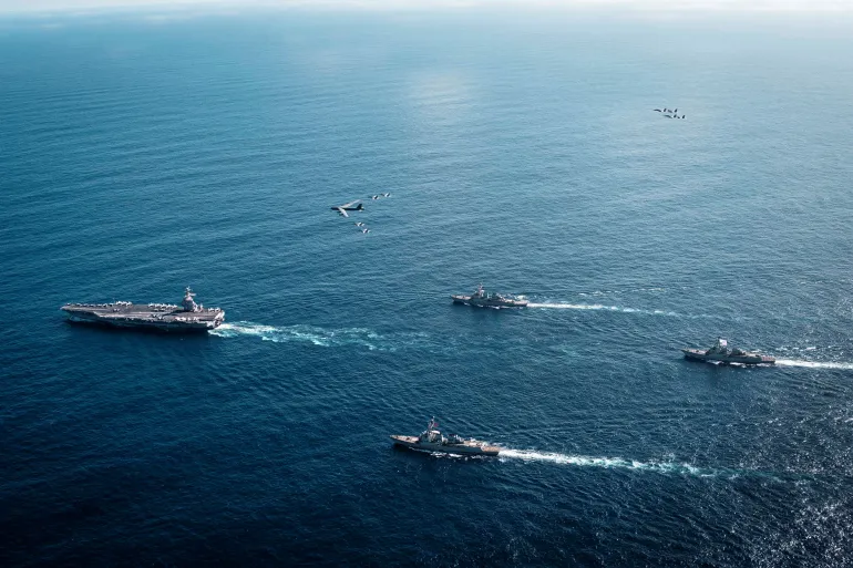 The U.S. Navy’s Gerald R. Ford Carrier Strike Group, including the flagship USS Gerald R. Ford, USS Winston S. Churchill, USS Mahan and USS Bainbridge, sail towards the Caribbean Sea under F/A-18E/F Super Hornets and a U.S. Air Force B-52 Stratofortress, in the Atlantic Ocean November 13, 2025.