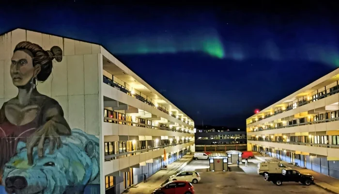 The Aurora Borealis (Northern Lights) is seen behind a building with social housings with a mural in Nuuk, Greenland, September 17, 2021. — Reuters