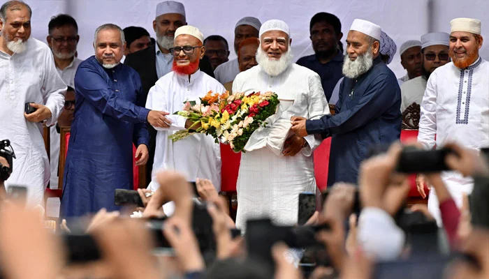 Bangladesh´s Jamaat-e-Islami party leader Ameer Shafiqur Rahman (centre R) presents a floral wreath to leader A.T.M. Azharul Islam (centre L) after his release from prison in Dhaka on May 28, 2025. — AFP