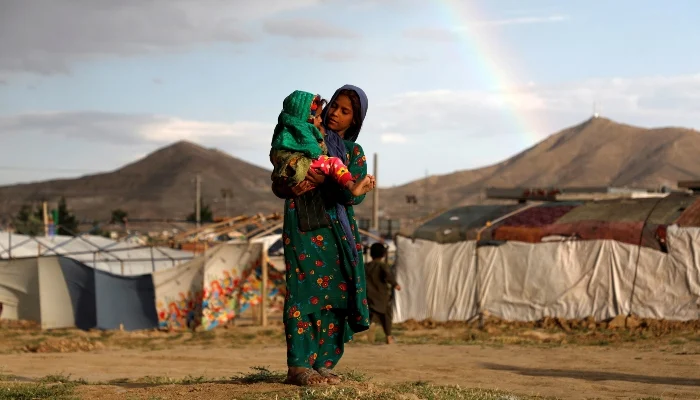An internally displaced Afghan girl carries a child near their shelter at a camp on the outskirts of Kabul, Afghanistan, June 20, 2019. — Reuters