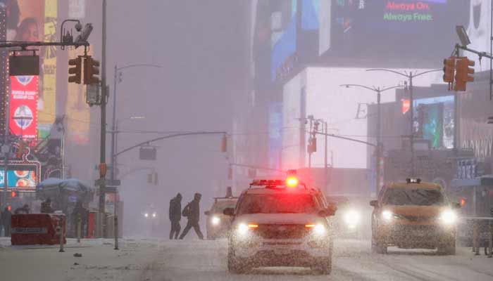 People cross the street during snowfall at Times Square, as a major winter storm spreads across a large swath of the United States, in New York City, US, January 25. — Reuters