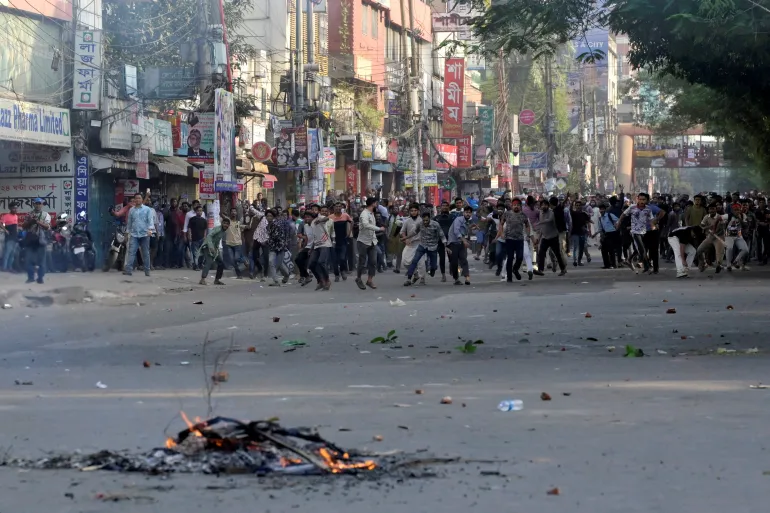 Demonstrators throw stones towards police during a protest demanding demolition of the house of Bangabandhu Sheikh Mujibur Rahman, father of the ousted Prime Minister Sheikh Hasina, after the verdict on cases against Sheikh Hasina, in Dhaka, Bangladesh, November 17, 2025 REUTERS/Fatima Tuj Johora