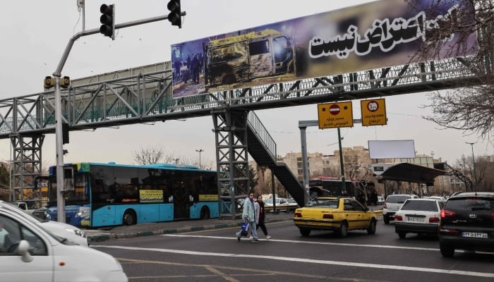 Commuters drive under a banner that reads This is not a protest in Tehran, Iran, January 15, 2026. — AFP