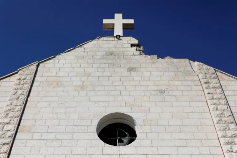 A view of the Holy Family Church which was damaged during the Israeli bombardment of the Gaza Strip, prior to the arrival of Palestinian Christians to celebrate Christmas Mass, in Gaza City, on December 24, 2025. The war was sparked by Hamas's October 7, 2023 attack on Israel, which resulted in the deaths of 1,221 people. Israel's retaliatory assault on Gaza has killed at least 69,733 people, according to figures from the health ministry that the UN considers reliable. (Photo by Omar AL-QATTAA / AFP)