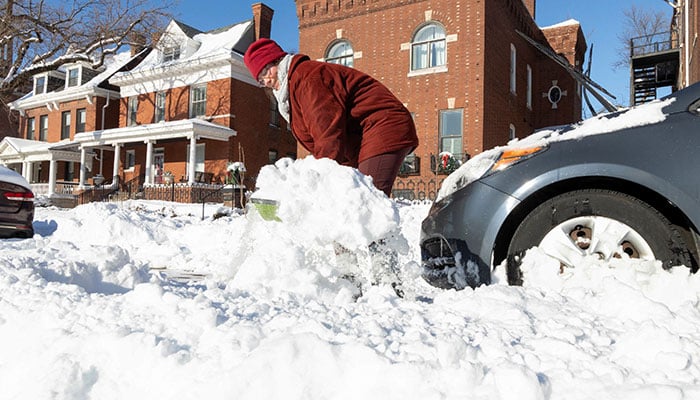 A resident clears snow from around a parked car on a residential street in the aftermath of a winter storm in the St. Louis area, Missouri, US, January 26, 2026. — Reuters