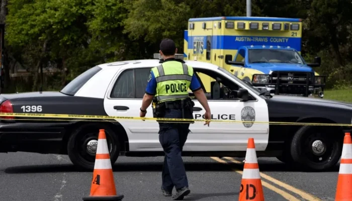 A Texas cop walks towards the police car parked in the background of a cordoned off site. — Reuters