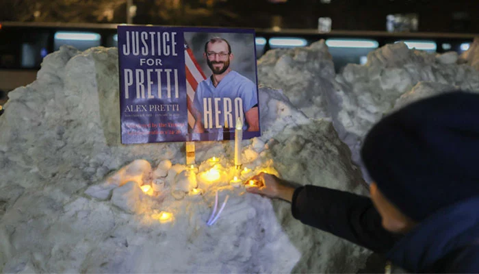 A man holds a portrait of Alex Pretti, a 37-year-old nurse who was fatally shot by immigration agents in Minneapolis, during a vigil for him at the Veterans Affairs NY Harbor Healthcare System Manhattan Campus in New York, on January 29, 2026. — AFP