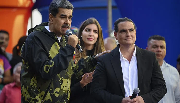Venezuela’s President Nicolas Maduro (left) speaks to supporters while standing next to Alex Saab at a pro‑government rally in Caracas last year. —  AFP