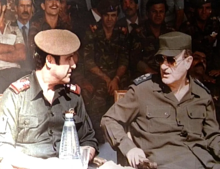 Picture taken in 1984 shows late Syrian president Hafez al-Assad (R) with his youngest brother Rifaat (L) at a military ceremony in Damascus. The estranged and banished brother, Rifaat, announced 12 June 2000 that he considers himself the legitimate successor to the presidency of Syria. The statement represents a direct challenge to the right of Bashar al-Assad, the late president's son and designated heir, to take the post. (Photo by Handout / AFP) / XGTY / == RESTRICTED TO EDITORIAL USE - MANDATORY CREDIT "AFP PHOTO / HO " - NO MARKETING NO ADVERTISING CAMPAIGNS - DISTRIBUTED AS A SERVICE TO CLIENTS == - XGTY / == RESTRICTED TO EDITORIAL USE - MANDATORY CREDIT "AFP PHOTO / HO " - NO MARKETING NO ADVERTISING CAMPAIGNS - DISTRIBUTED AS A SERVICE TO CLIENTS == / BEST QUALITY AVAILABLE