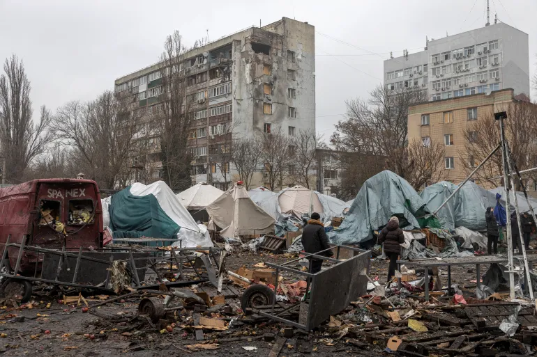 People walk among debris of a local market close to damaged residential building at the site of a Russian attack in Odesa on February 12, 2026, amid the Russian invasion of Ukraine. (Photo by Oleksandr GIMANOV / AFP)