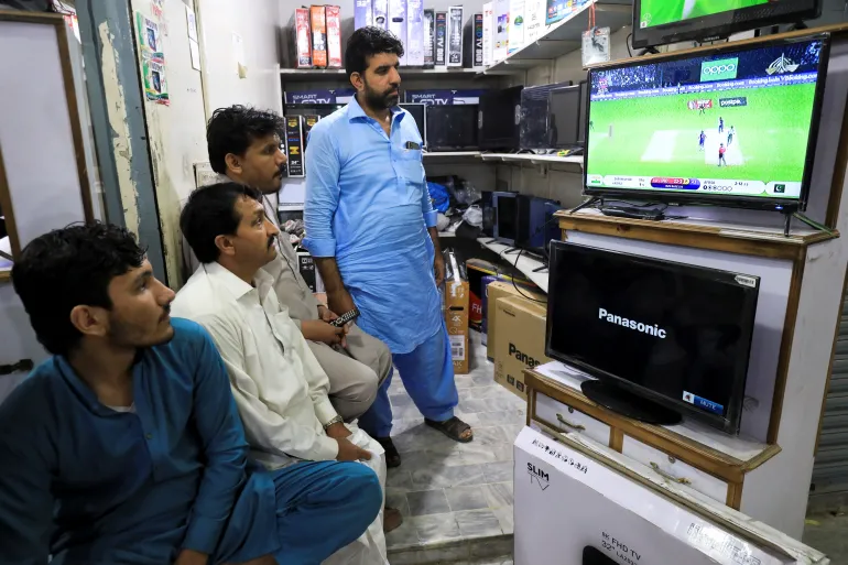Pakistani cricket fans watch the first match between India and Pakistan in Twenty20 World Cup Super 12 stage in Dubai, on a television screen at a shop in Peshawar, Pakistan October 24, 2021. REUTERS/Fayaz Aziz