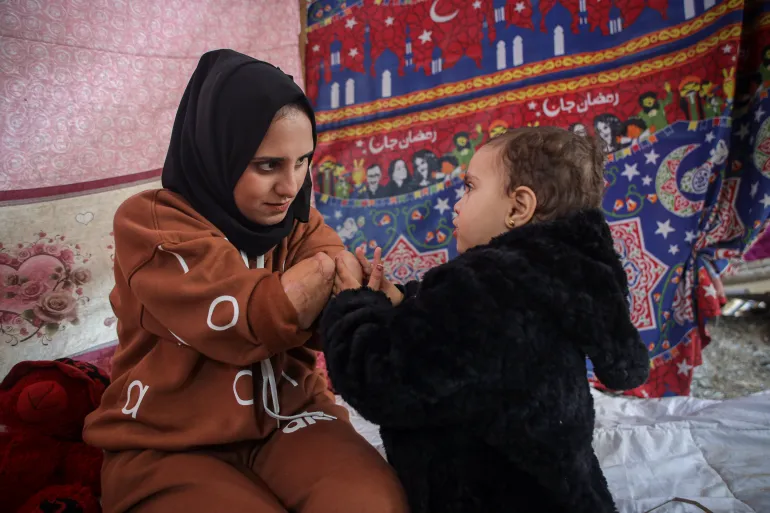 Nebal with her two-year-old daughter, Rita [Abdelhakim Abu Riash/ Al Jazeera] 