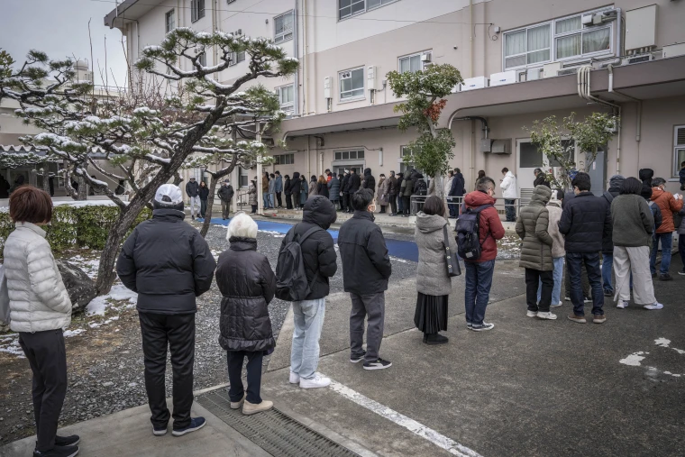 People queue up at a polling station to vote during the House of Representatives election in Kawasaki, Kanagawa prefecture.