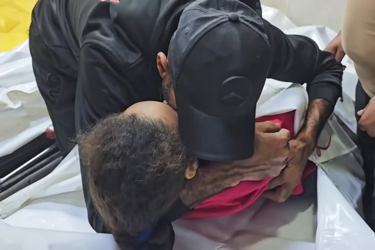 Rami Essam Abu Jamea and his family members cry while kneeling on the floor