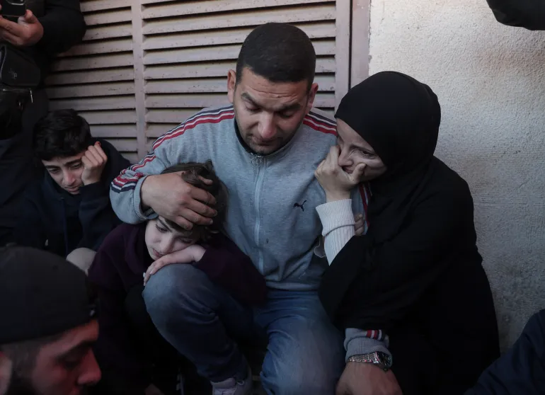 Mohammed Wishah’s family bids him a final farewell before his burial at Al-Aqsa [Abdelhakim Abu Riash/ Al Jazeera]