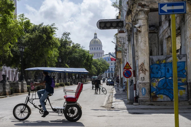 A pedicab drives past a traffic light that is out due to a power cut in Havana, Cuba.