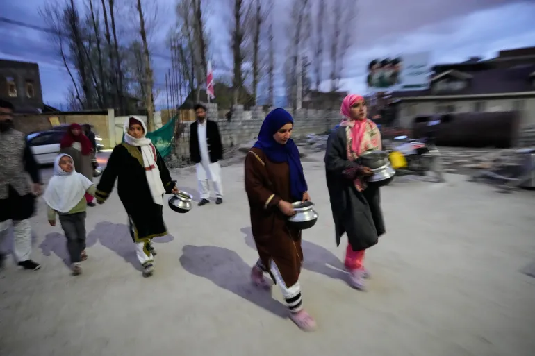 Shiite Muslim women arrive carrying kitchenware to donate at a relief drive for Iran in Budgam, Indian-controlled Kashmir, Monday, March 23, 2026. (AP Photo/Mukhtar Khan)
