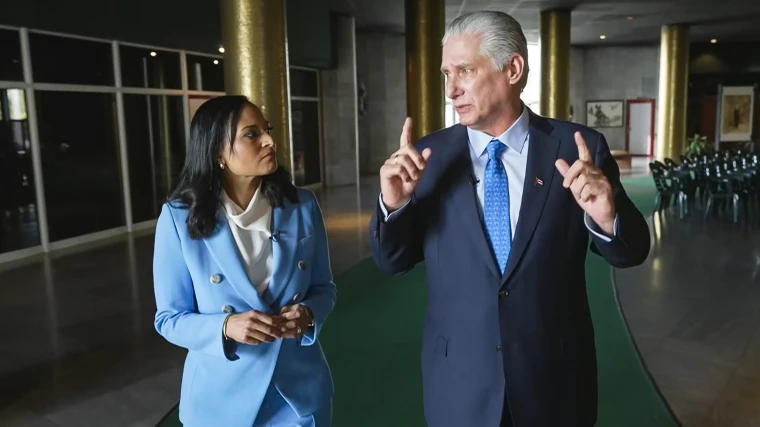 Kristen Welker and Miguel Díaz-Canel speak to each other while walking inside of a building
