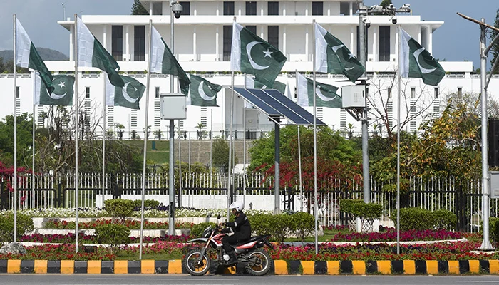 A man rides a motorcycle past the President house as Pakistan gears up to host the US and Iran for peace talks, in Islamabad, on April 9, 2026. — Reuters
