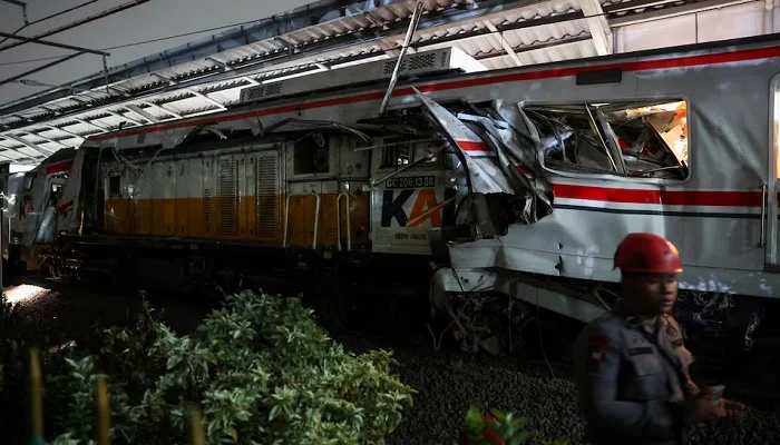 A police officer stands near the damaged train, after two trains collided late on Monday in Bekasi, West Java province, Indonesia, April 28, 2026.— Reuters