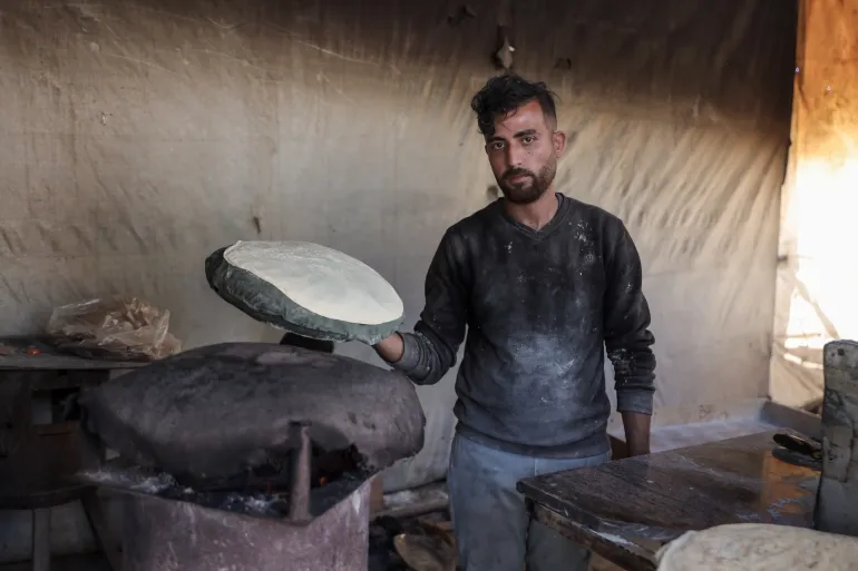 Yousef Al-Rifi during his work in one of the temporary bakeries in central Gaza City, as a job opportunity to help support his family and his two children