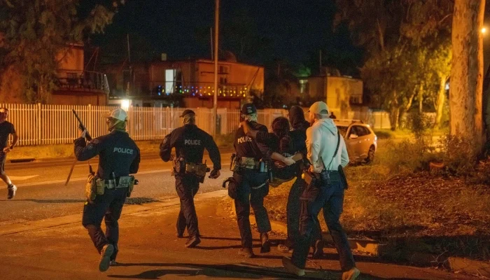 A woman is carried by police during community unrest outside Alice Springs Hospital, where a 47-year-old man arrested in connection with the alleged killing of five-year-old Kumanjayi Little Baby was taken, in Alice Springs, Australia, April 30, 2026. — Reuters