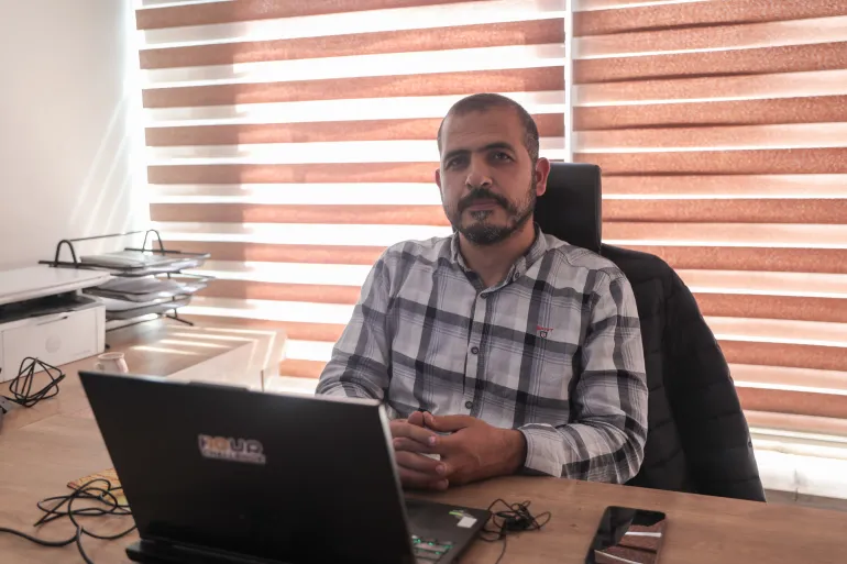 Man sits at desk with laptop open