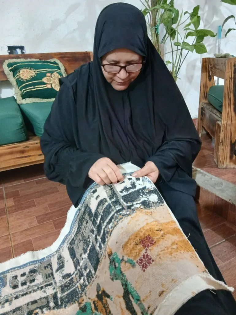 A Palestnian embroiderer stitches the panel 'Shifa Hospital'. Ain Al-Haleweh Refugee Camp, Lebanon [Courtesy of Palestine Museum]