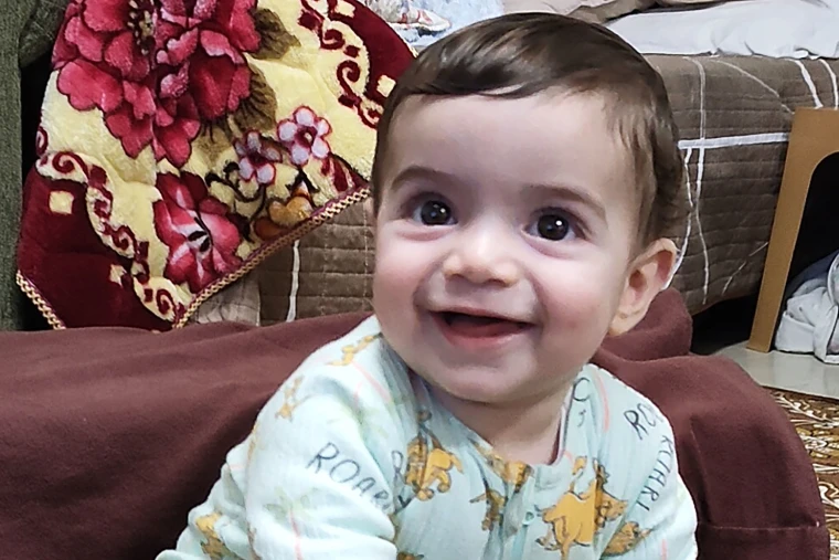 The 7-month-old was in his mother's arms when he was fatally shot.