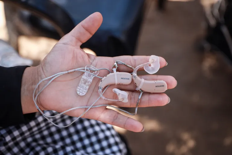 Hand holding hearing aid