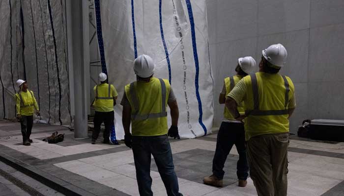 Workers raise a tarp in preparation for the removal of lettering from the facade of the John F Kennedy Memorial Center for the Performing Arts, following a federal judge’s order to remove US President Donald Trumps name from the institution, in Washington, DC, US, June 13, 2026. — Reuters