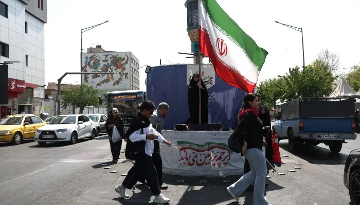 A woman holds an Iranian flag on a street in Tehran, Iran, June 10, 2026. — Reuters