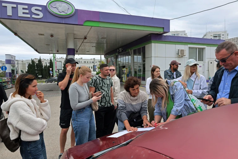 People put their names on a list to join the queue for fuel at a gas station in Sevastopol