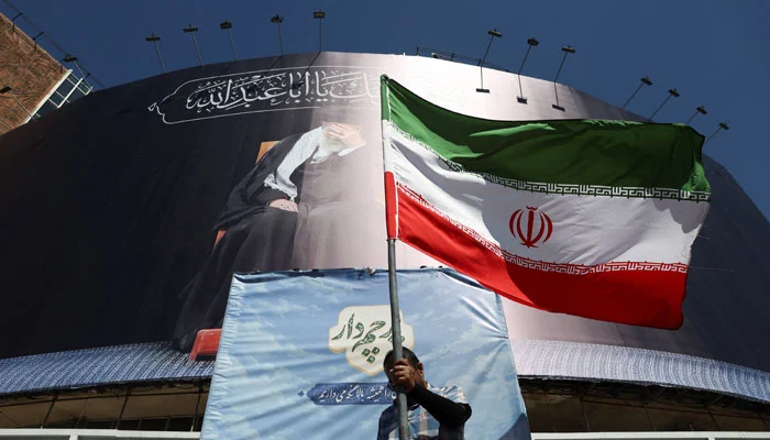 A man holds an Iranian flag on a street, after U.S. and Iranian officials said they had reached a deal to end their war and reopen the Strait of Hormuz, in Tehran, Iran, June 15, 2026.— Reuters/File