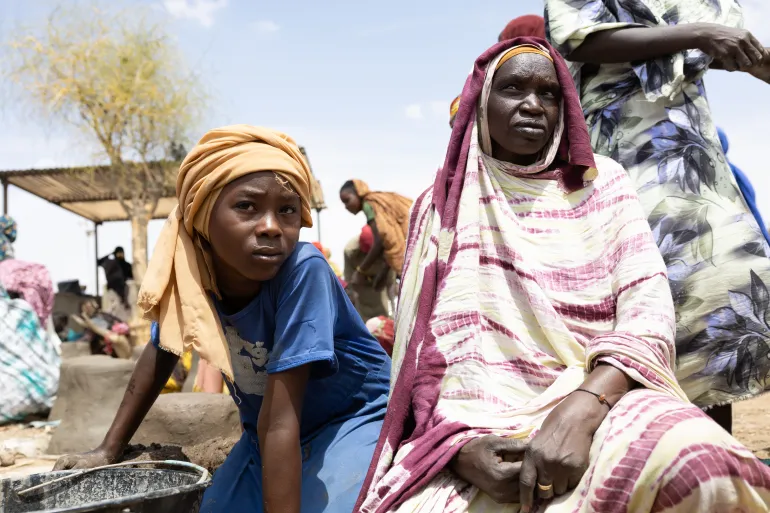 Fatne Adam (right), who fled Sudan in 2023, has lived in Metche refugee camp in eastern Chad ever since. She says her husband and son were shot by snipers as the family escaped the war.